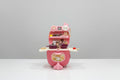 Pink toy kitchen set with cartoon character on a white surface