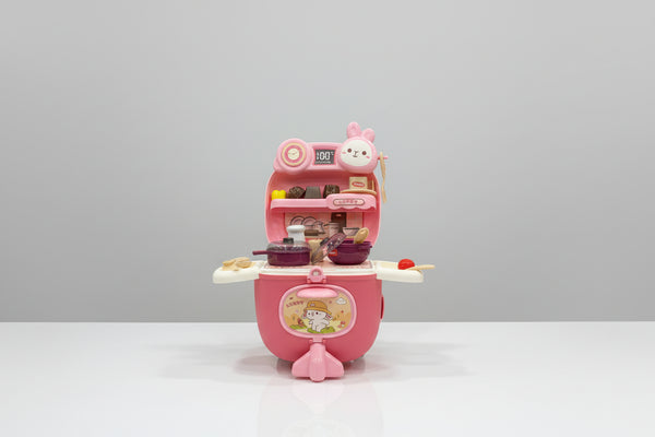 Pink toy kitchen set with cartoon character on a white surface